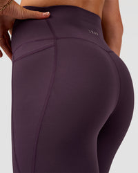 Woman wearing Elixir Ultra High-Rise 7/8 Legging Pockets - Midnight Plum | Model:Emelia | Size:S