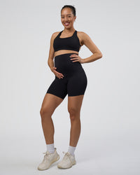 Woman wearing Elixir Ultra High-Rise Maternity 6" Short Pockets - Black | Model:Kitahna | Size:S