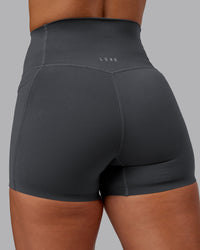 Woman wearing Elixir Ultra High-Rise 4" Short Pockets - Dark Storm | Model:Lyss | Size:S