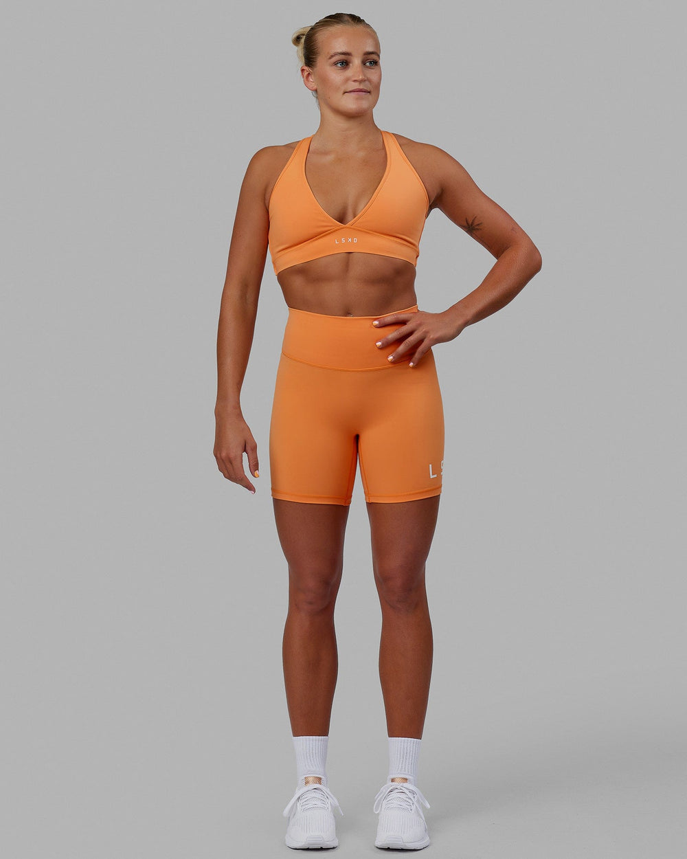 Woman wearing Evolved Mid Short Tight - Tangerine