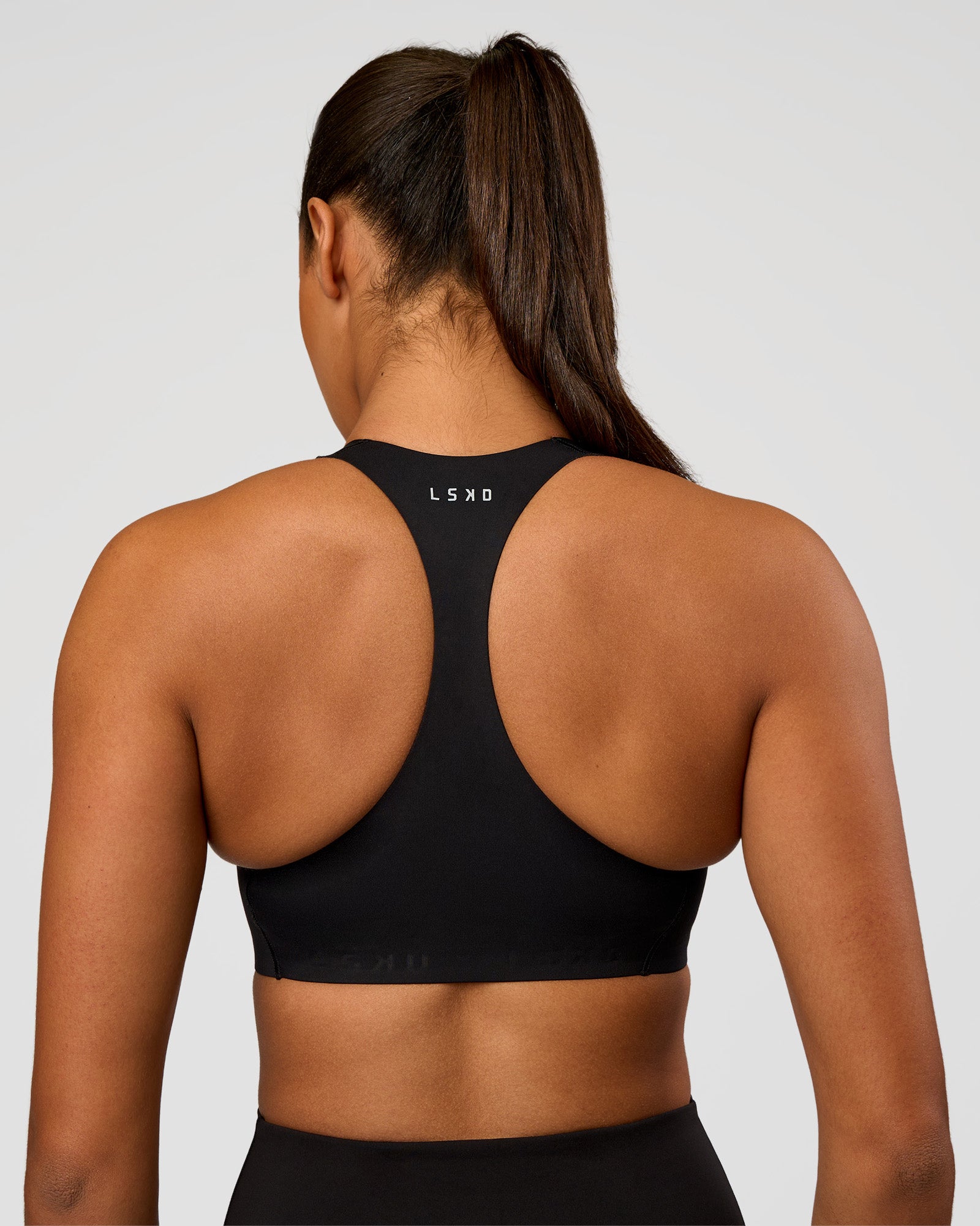 Woman wearing Flow Bonded Scoop Neck Sports Bra - Black | Model:Rosie | Size:S