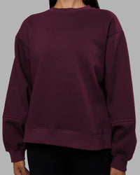 Woman wearing Full Form Fleece Sweater with Side Slits - Cherry Lacquer | Model:Rhiley | Size:S