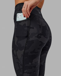 Woman wearing Fusion Ultra High-Rise 7/8 Legging Pockets - Black-Camo | Model:Katie | Size:S