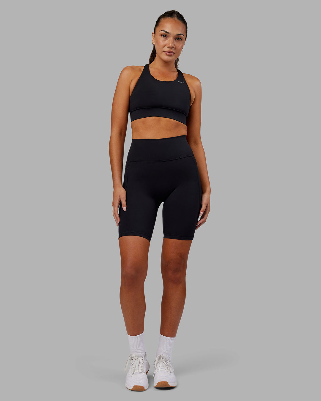 Woman wearing Fusion Ultra High-Rise 9" Short Pockets - Black | Model:Kirstyn | Size:S