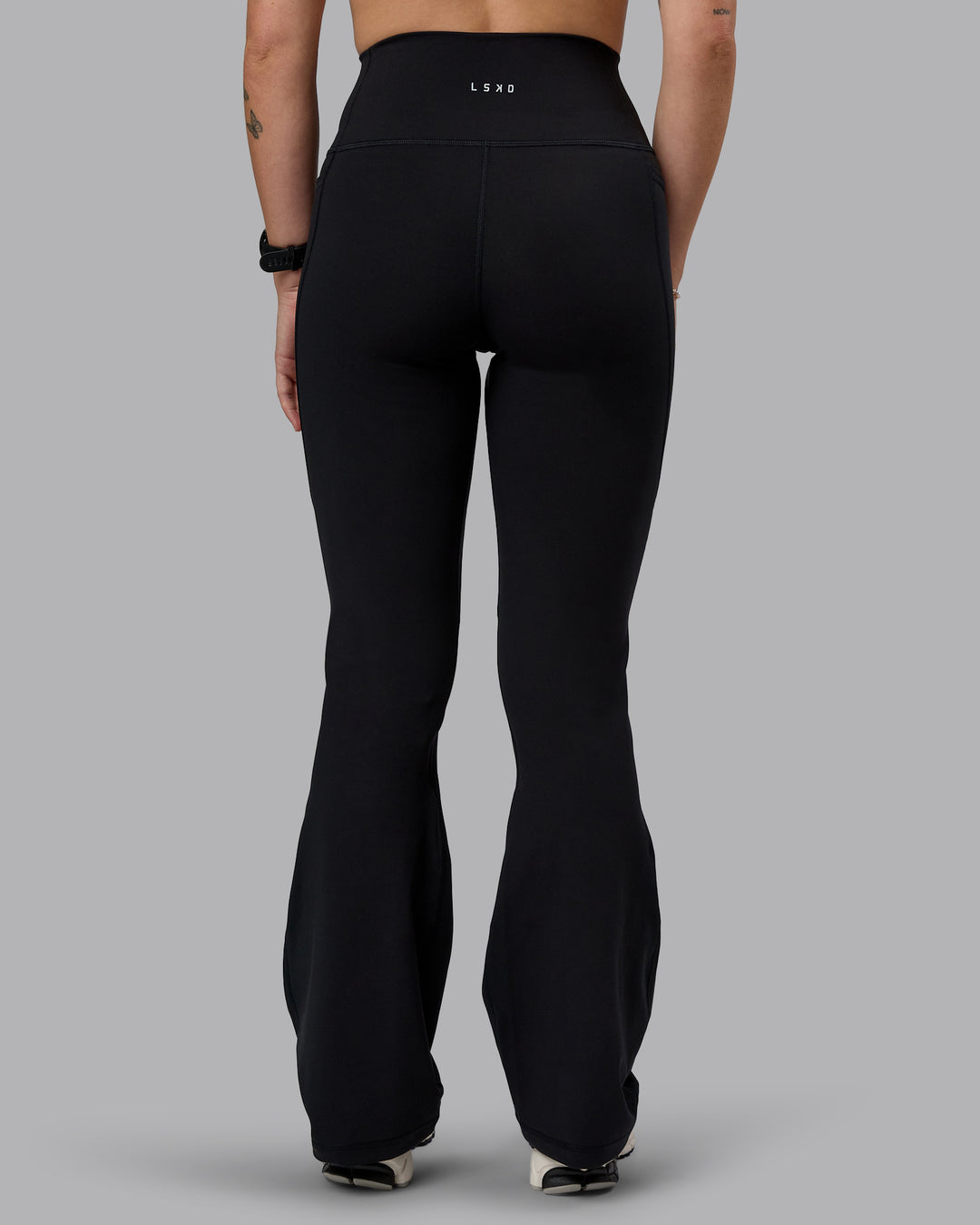 Woman wearing Fusion Ultra High-Rise Flared Petite Legging Pockets - Black| Model:Bianca | Size:S