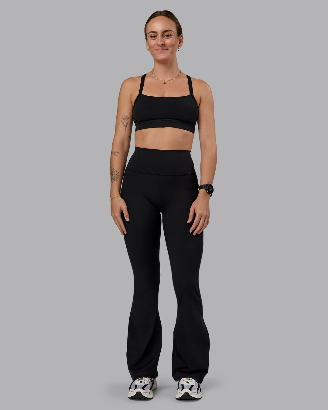 Woman wearing Fusion Ultra High-Rise Flared Petite Legging Pockets - Black| Model:Bianca | Size:S
