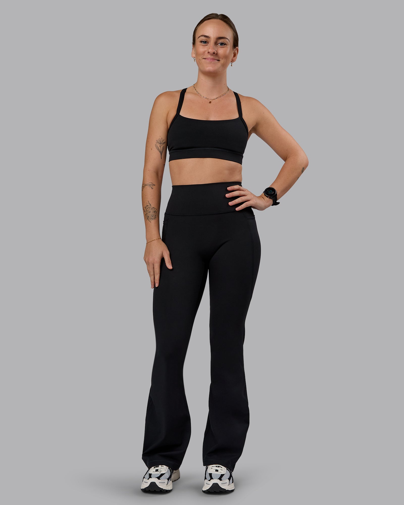 Woman wearing Fusion Ultra High-Rise Flared Petite Legging Pockets - Black| Model:Bianca | Size:S
