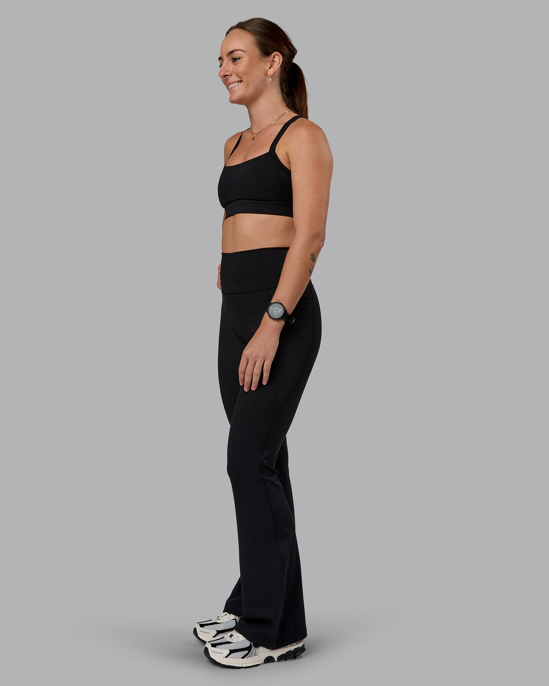 Woman wearing Fusion Ultra High-Rise Flared Petite Legging Pockets - Black| Model:Bianca | Size:S