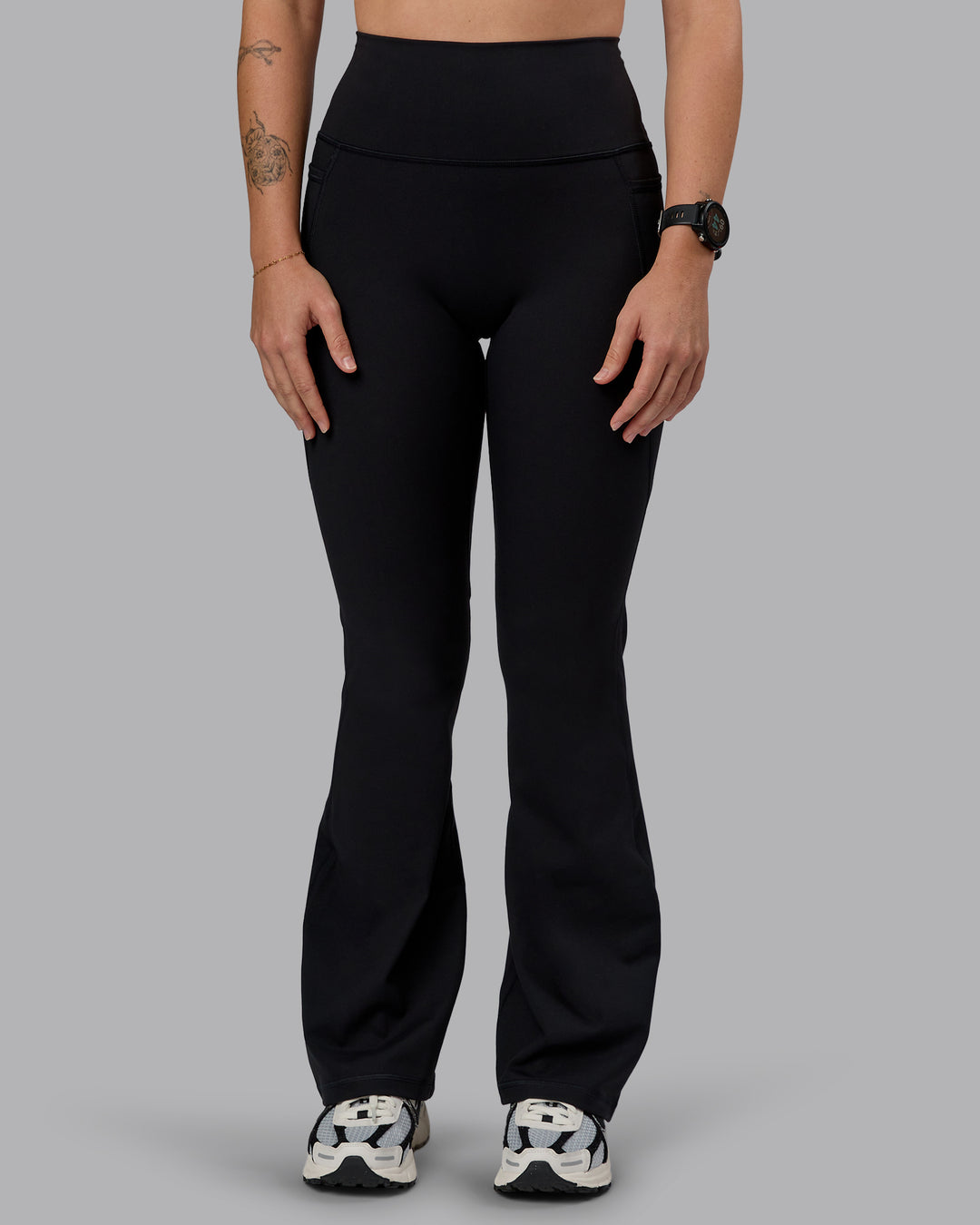 Woman wearing Fusion Ultra High-Rise Flared Petite Legging Pockets - Black| Model:Bianca | Size:S