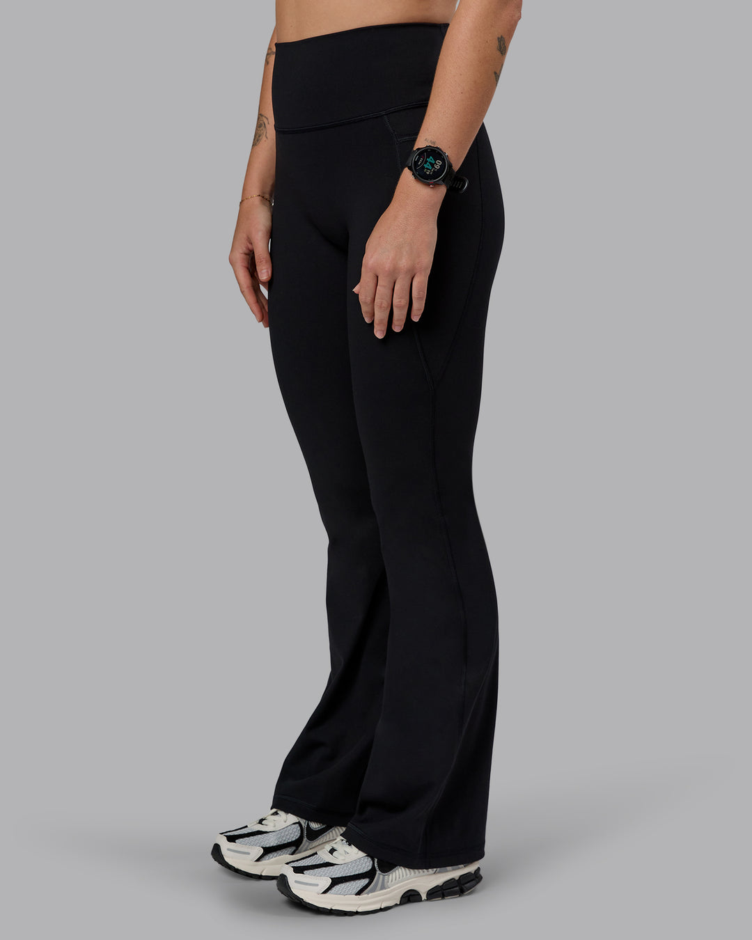 Woman wearing Fusion Ultra High-Rise Flared Petite Legging Pockets - Black| Model:Bianca | Size:S