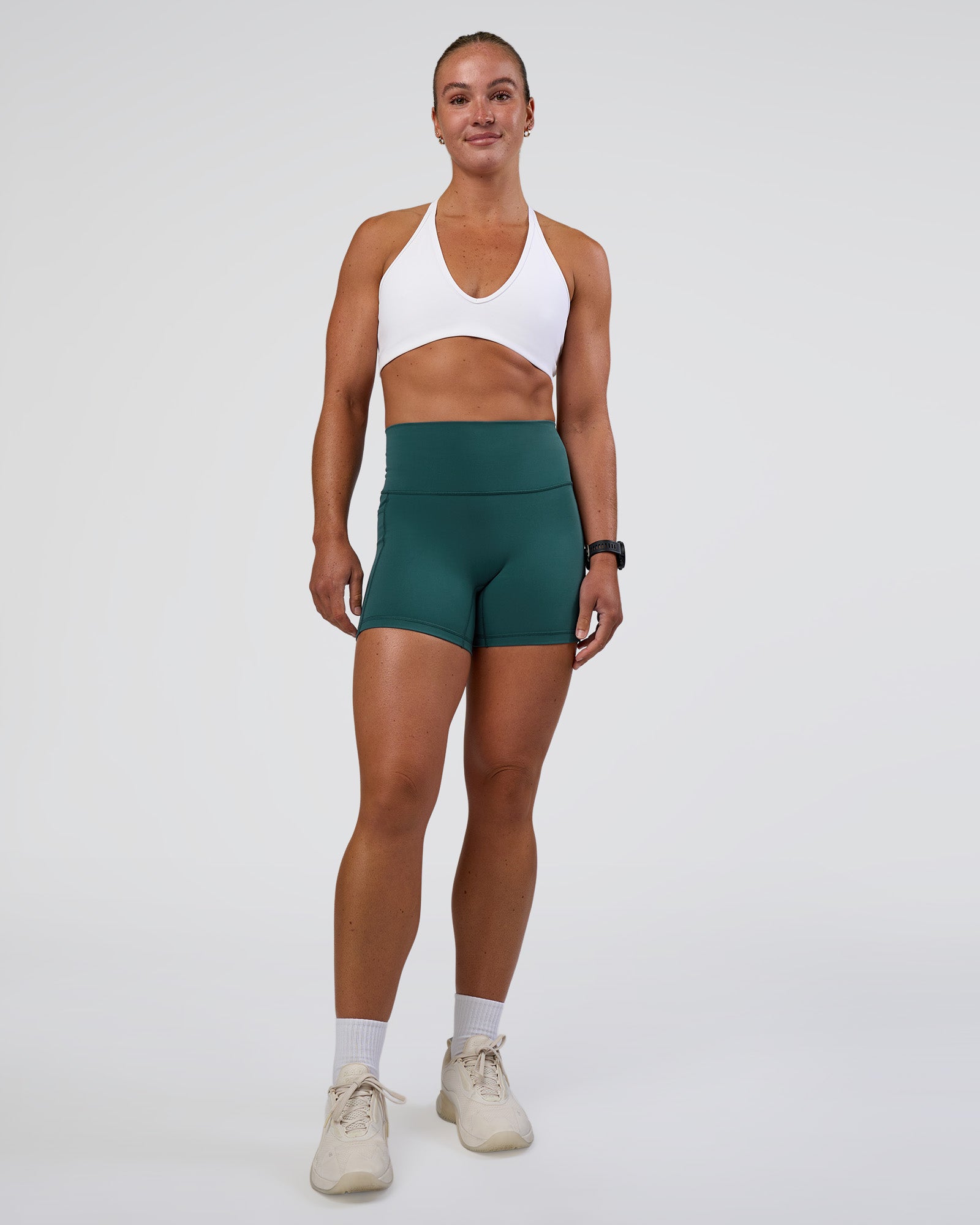 Woman wearing Fusion High-Rise 4" Short Pockets - Transformative Teal | Model:Sav | Size:S