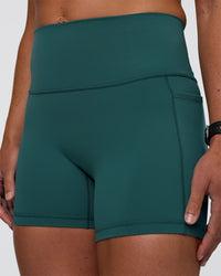 Woman wearing Fusion High-Rise 4" Short Pockets - Transformative Teal | Model:Sav | Size:S