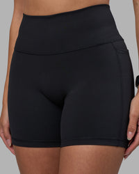 Woman wearing Fusion High-Rise 6" Short Pockets - Black | Model:Rhiley | Size:S