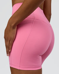 Woman wearing Fusion High-Rise 6" Short Pockets - Candy Pink | Model:Rosie | Size:S