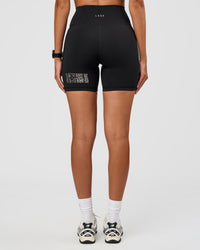 Woman wearing Fusion Hype Graphic Ultra High-Rise 6" Short Pockets - Black-Alloy | Model:Rhiley | Size:S