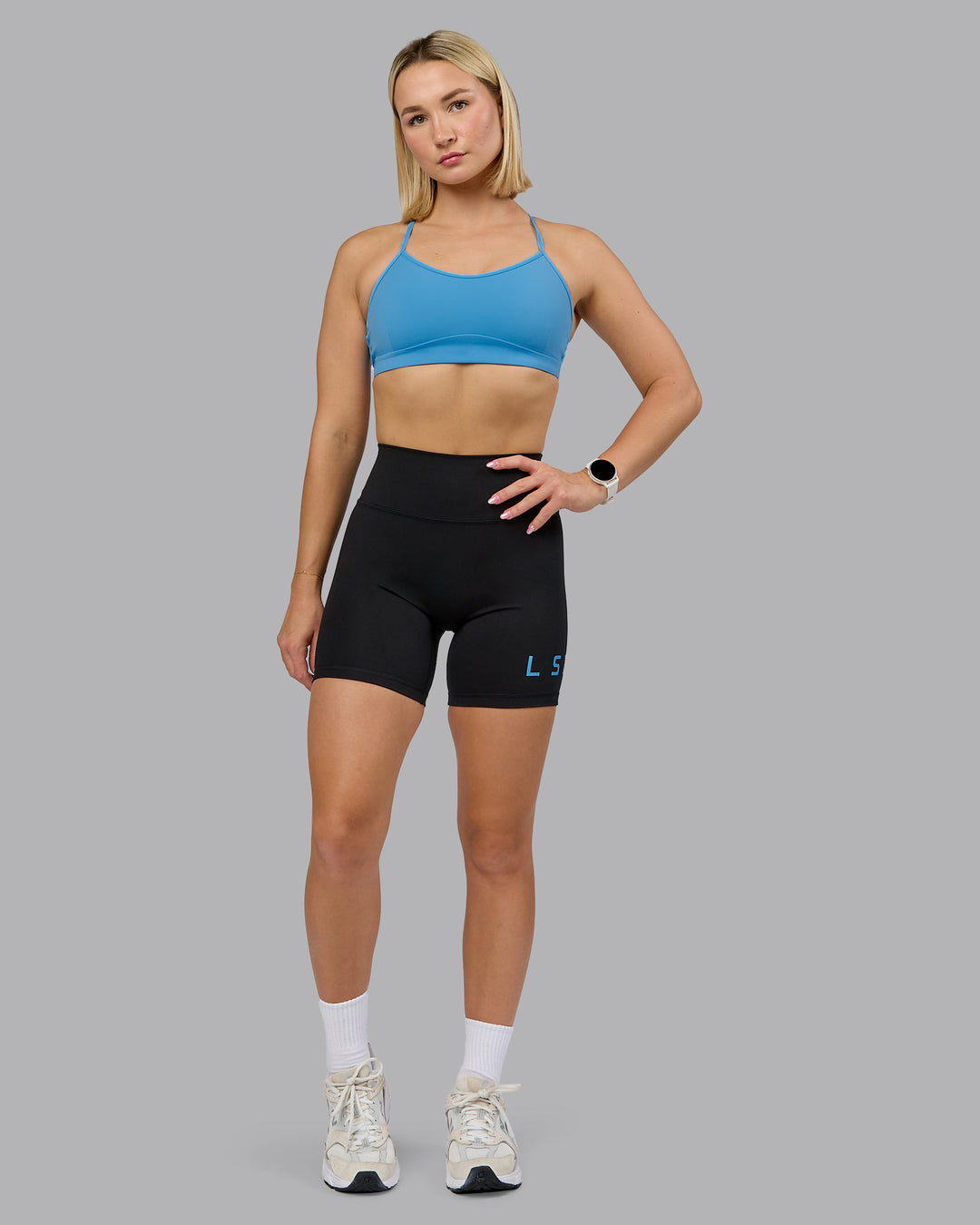 Woman wearing Fusion Ultra High-Rise 6&quot; Short Logo - Black-Azure Blue | Model:Halle | Size:S