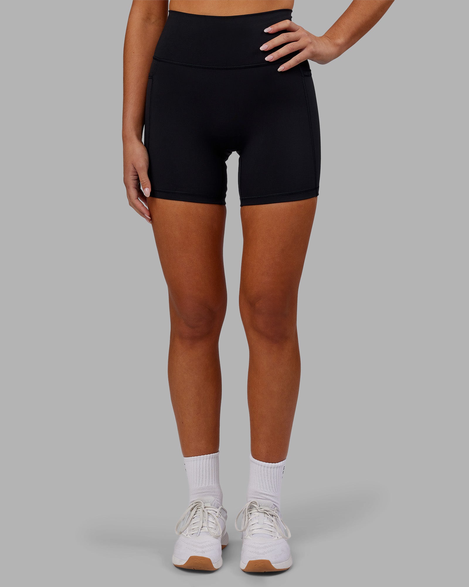 Woman wearing Fusion Ultra High-Rise 6" Short Pockets - Black | Model:Kirstyn | Size:S