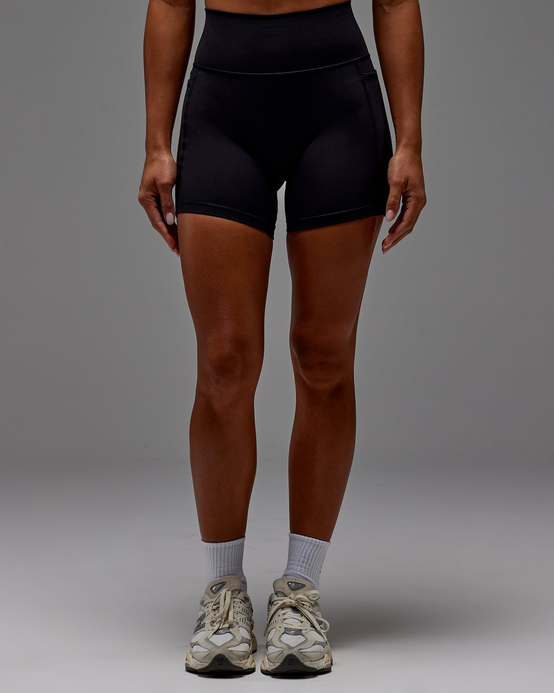 Woman wearing Fusion Ultra High-Rise 6" Short Pockets - Black | Model:Demi | Size:S