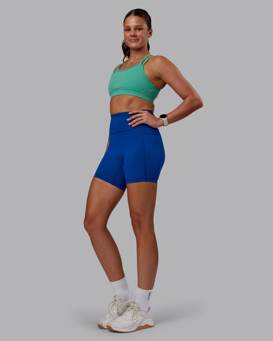 Woman wearing Fusion Ultra High-Rise 6&quot; Short Pockets - Blue Quartz | Model:Phoebe | Size:S
