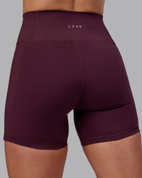 Woman wearing Fusion Ultra High-Rise 6" Short Pockets - Cherry Lacquer | Model:Paris | Size:S