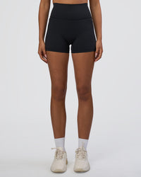 Woman wearing Fusion Ultra High-Rise 4" Short Pockets - Black | Set:true | Angle:front | Model:Ruby | Size:S