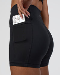 Woman wearing Fusion Ultra High-Rise 4" Short Pockets - Black | Set:true | Angle:closeup | Model:Ruby | Size:S
