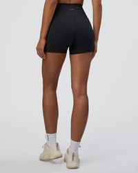 Woman wearing Fusion Ultra High-Rise 4" Short Pockets - Black | Set:true | Angle:back | Model:Ruby | Size:S