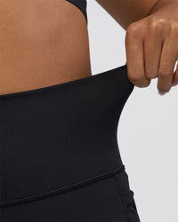 Woman wearing Fusion Ultra High-Rise 4" Short Pockets - Black | Model:Ruby | Size:S