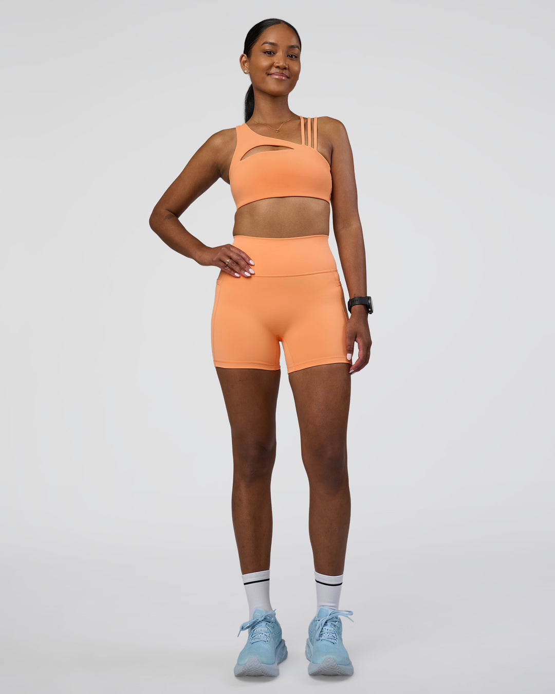 Woman wearing Fusion Ultra High-Rise 4&quot; Short Pockets - Cantaloupe | Model:Rica | Size:S