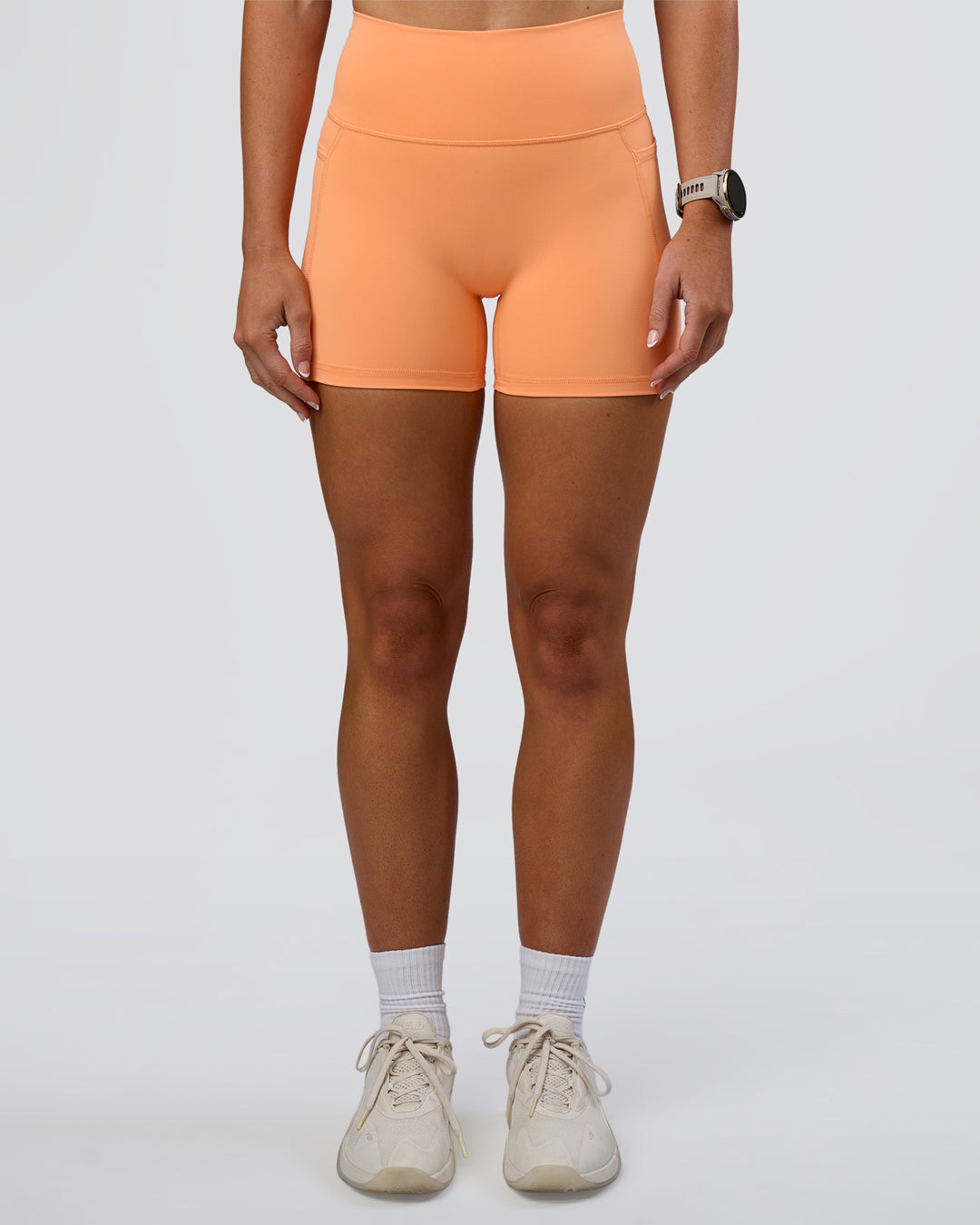 Woman wearing Fusion Ultra High-Rise 4" Short Pockets - Cantaloupe | Model:Emelia | Size:S