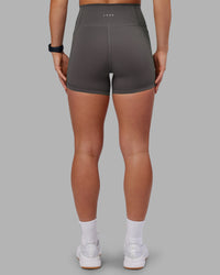 Woman wearing Fusion Ultra High-Rise 4" Short Pockets - Dark Storm | Model:Keisha | Size:S