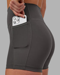 Woman wearing Fusion Ultra High-Rise 4" Short Pockets - Dark Storm | Model:Keisha | Size:S