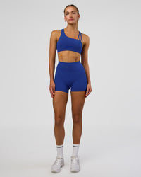 Woman wearing Fusion Ultra High-Rise 4" Short Pockets - Electric Indigo | Model:Evie | Size:S