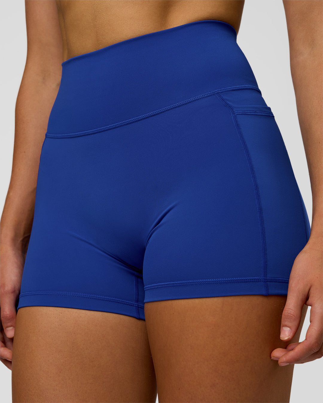 Woman wearing Fusion Ultra High-Rise 4" Short Pockets - Electric Indigo | Model:Evie | Size:S