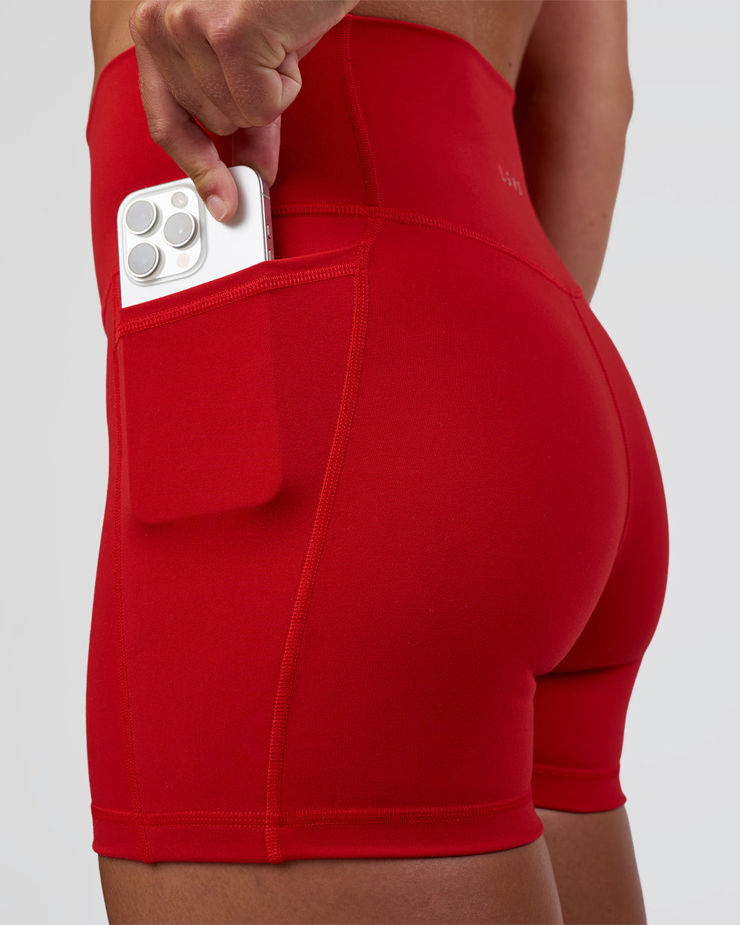 Woman wearing Fusion Ultra High-Rise 4&quot; Short Pockets - Flame | Model:Sav | Size:S