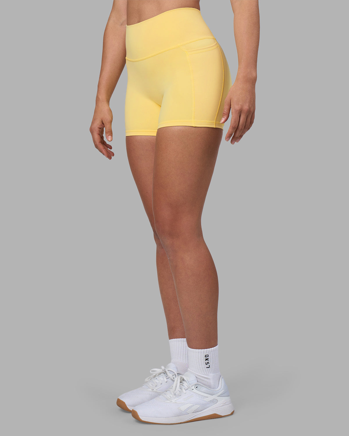 Woman wearing Fusion Ultra High-Rise 4" Short Pockets - Lemon | Model:Sophie | Size:S