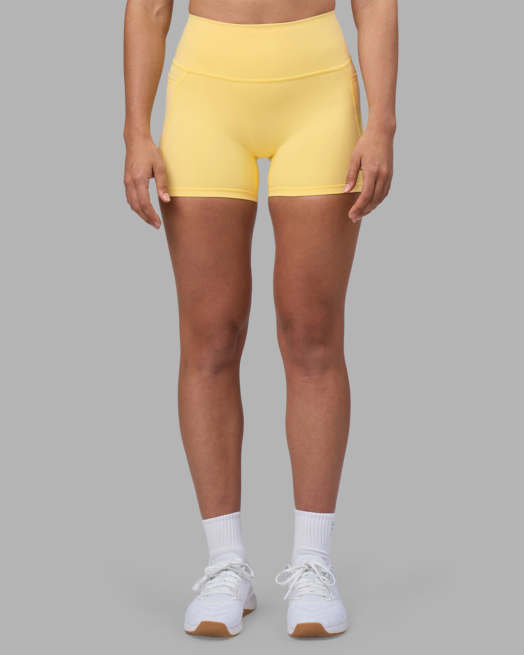 Woman wearing Fusion Ultra High-Rise 4" Short Pockets - Lemon | Model:Sophie | Size:S