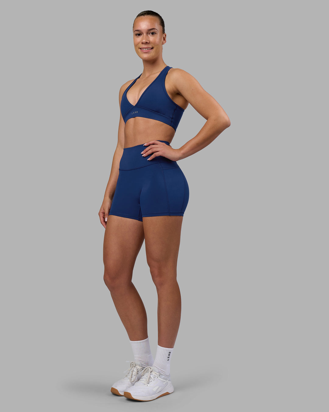 Woman wearing Fusion Ultra High-Rise 4&quot; Short Pockets - Midnight Blue | Model:Charlize | Size:S