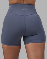 Woman wearing Fusion Ultra High-Rise 4" Short Pockets - Night Shadow | Model:Rhiley | Size:S