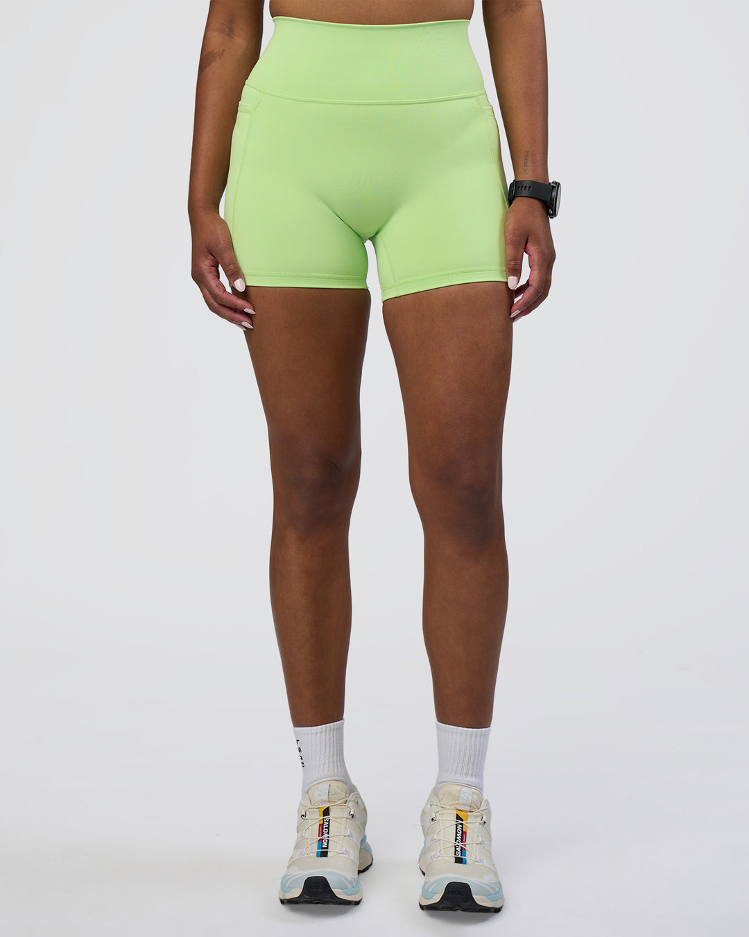 Woman wearing Fusion Ultra High-Rise 4&quot; Short Pockets - Solar Lime | Model:Rica | Size:S