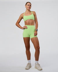 Woman wearing Fusion Ultra High-Rise 4" Short Pockets - Solar Lime | Model:Emelia | Size:S
