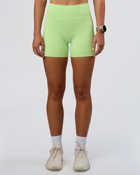 Woman wearing Fusion Ultra High-Rise 4" Short Pockets - Solar Lime | Set:true | Angle:front | Model:Emelia | Size:S