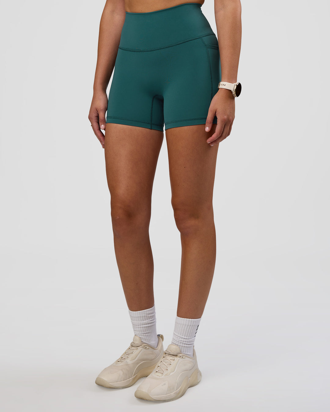 Woman wearing Fusion Ultra High-Rise 4" Short Pockets - Transformative Teal | Set:true | Angle:side | Model:Myrte | Size:S