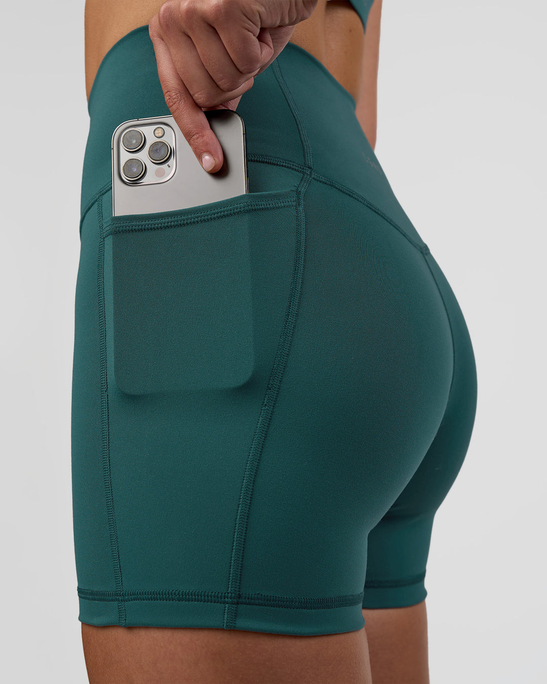 Woman wearing Fusion Ultra High-Rise 4" Short Pockets - Transformative Teal | Set:true | Angle:closeup | Model:Myrte | Size:S