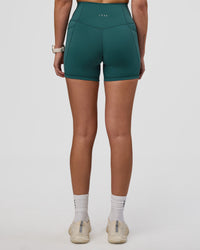 Woman wearing Fusion Ultra High-Rise 4" Short Pockets - Transformative Teal | Set:true | Angle:back | Model:Myrte | Size:S