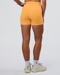 Woman wearing Fusion Ultra High-Rise 4" Short Pockets - Warm Apricot | Set:true | Angle:back | Model:Emelia | Size:S