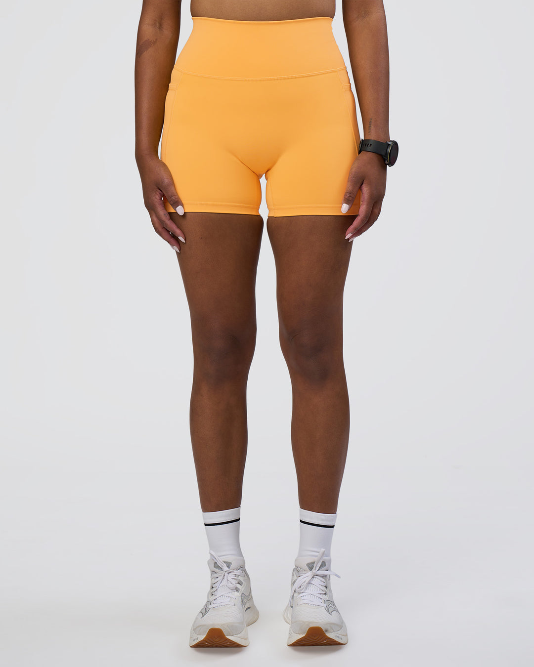 Woman wearing Fusion Ultra High-Rise 4&quot; Short Pockets - Warm Apricot | Model:Rica | Size:S