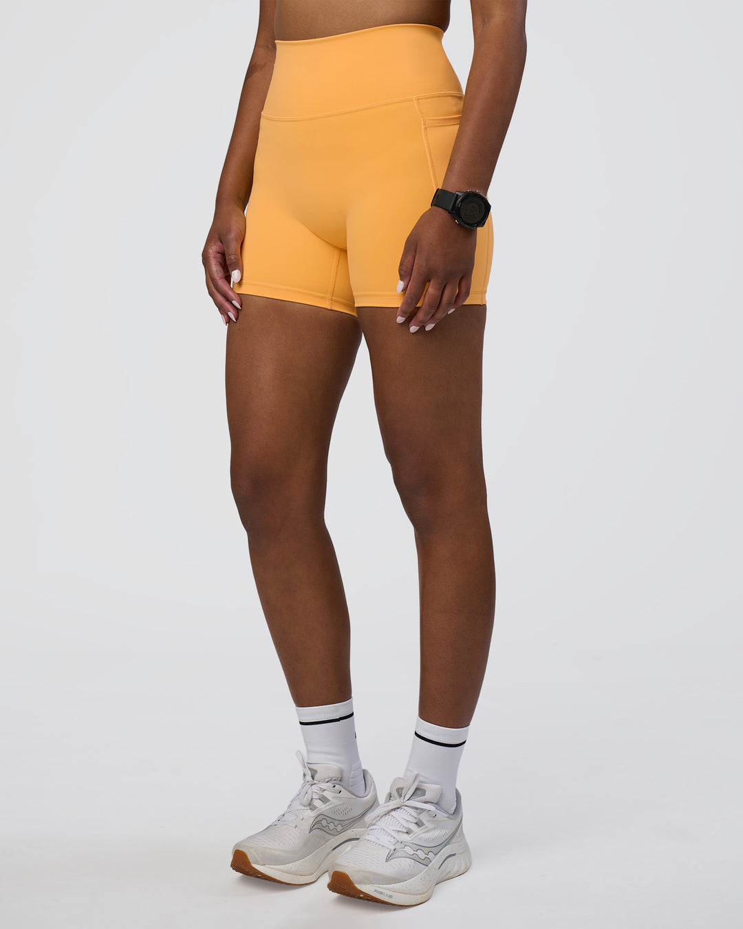 Woman wearing Fusion Ultra High-Rise 4&quot; Short Pockets - Warm Apricot | Model:Rica | Size:S