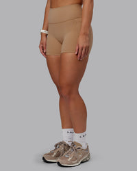 Woman wearing Fusion Ultra High-Rise 4" Short Pockets - Warm Smoke | Set:true | Angle:side | Model:Lyss | Size:S