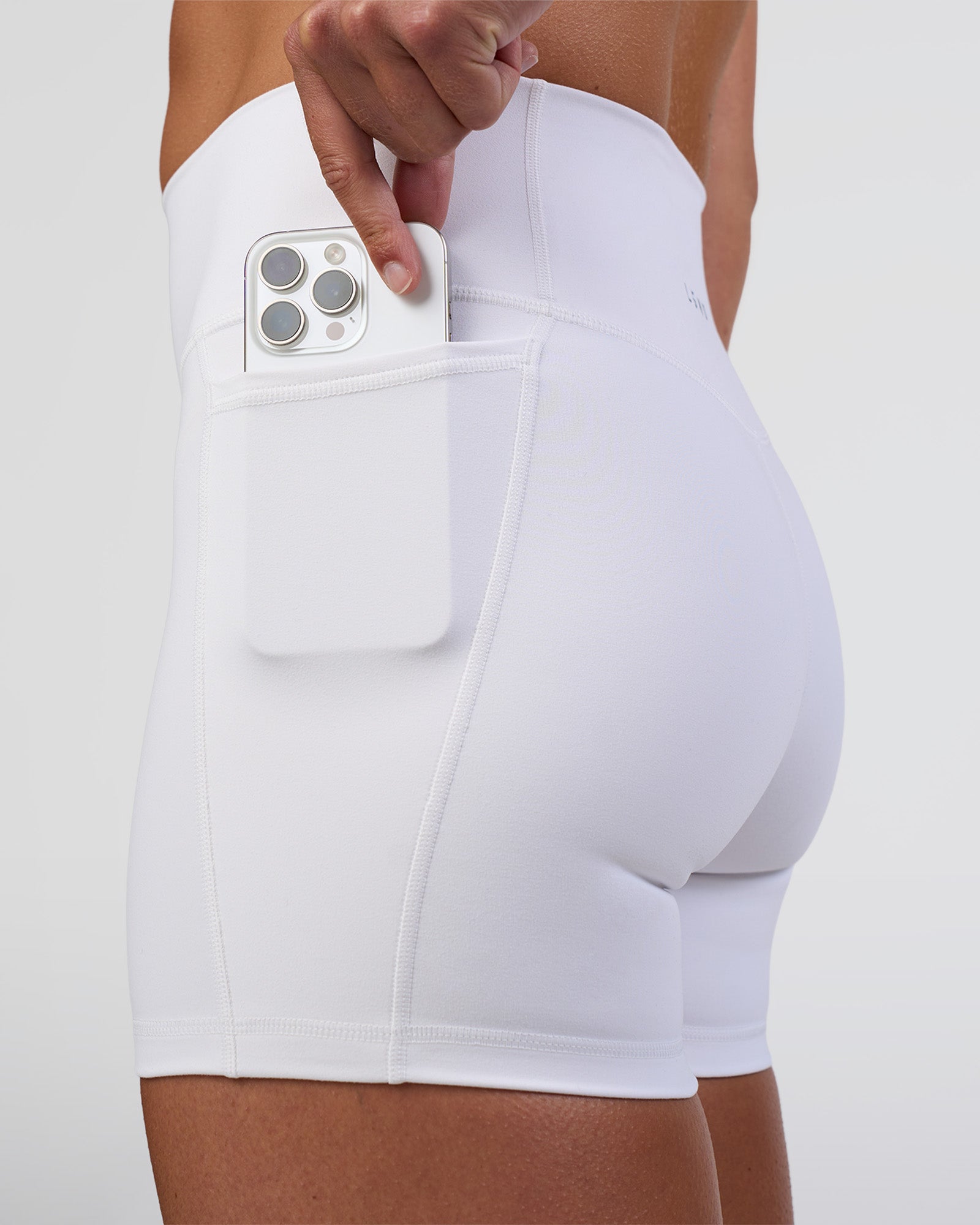 Woman wearing Fusion Ultra High-Rise 4" Short Pockets - White | Set:true | Angle:closeup | Model:Sav | Size:S